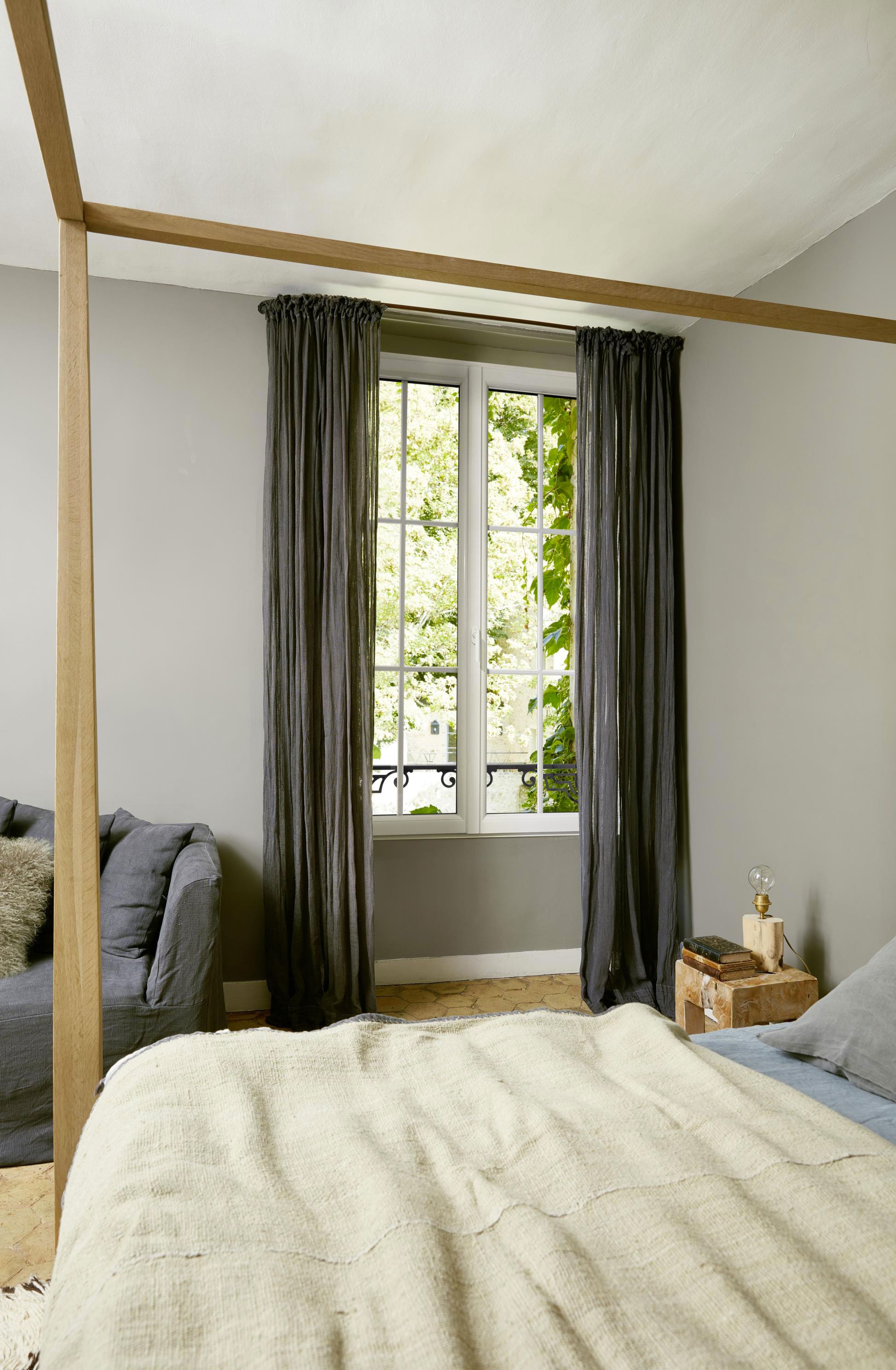 Fenêtre sur mesure avec rideaux gris dans une chambre aux tons gris et écru