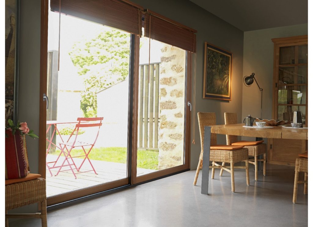 Baie coulissante vitrée vue depuis un intérieur décoré en bois