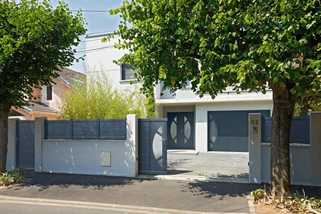 Porte de garage grise coulissante sur mesure d'un pavillon