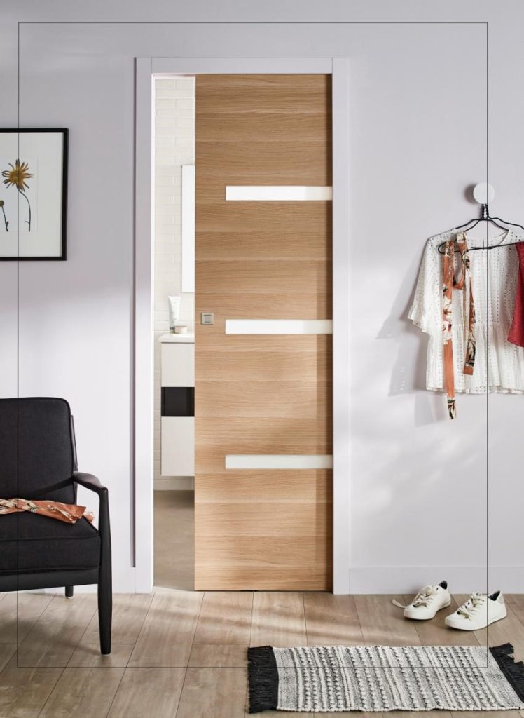 porte coulissante à galandage en bois dans une chambre donnant sur salle de bain
